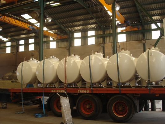 Depósitos cilíndricos amarrados sobre un camión góndola listos para la entrega